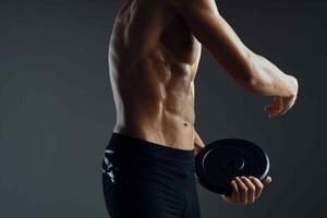 sporty man with a pumped-up muscular body in a towel dark background photo