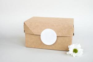 Round sticker mockup on kraft box, lunchbox, eco-friendly packaging with blank sticker, food box photo