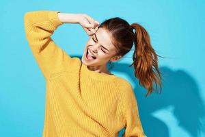 woman in yellow sweater fashion lifestyle cropped view blue background photo