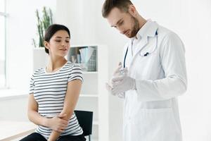 male doctor with a vaccine in his hands next to a hospital patient photo