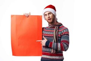 Cheerful man in New Year's clothes holding a banner holiday copy-space studio photo