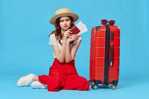 woman with red suitcase passport and plane tickets vacation destination photo