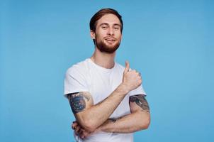 man in white t-shirt showing thumb up blue background studio photo