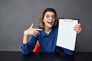 Business woman sits at a work table folder in hands Copy Space photo
