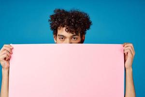 guy with curly hair holding pink Poster mockup Coffee Space photo