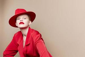 bonito mujer rojo chaqueta y sombrero rojo labios Moda estudio modelo inalterado foto