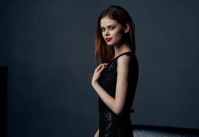 Portrait of elegant lady in black dress in gray room cropped view photo