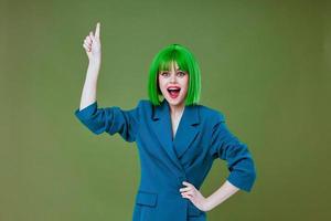 Portrait of a charming lady wearing a green wig blue jacket posing color background unaltered photo