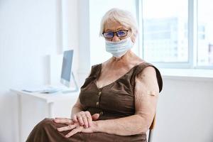 elderly woman wearing glasses medical mask hospital vaccine passport photo