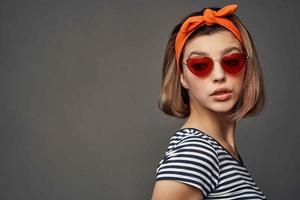 mujer vistiendo Gafas de sol con naranja vendaje en cabeza aislado antecedentes Moda foto