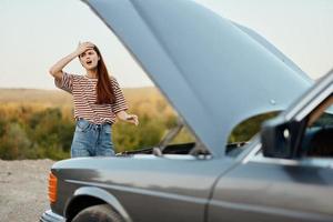 Woman is sad and angry about car breakdown on road trip alone and crying photo