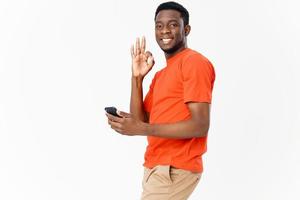happy guy of african appearance gesturing with his hands and holding a mobile phone photo