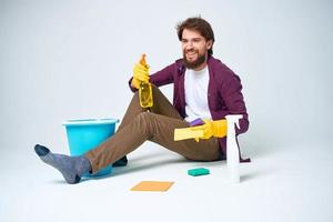Cleaner sits on the floor with a bucket of homework service room interior photo