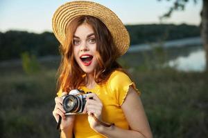 sorprendido mujer con abierto boca cámara en manos naturaleza viaje vacaciones foto