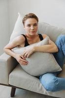 Young woman with short haircut hair having fun at home on the couch smile and happiness, vacation at home, natural posing without filters, free copy space photo