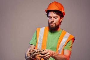 Man in construction uniform orange hard hat cropped view over beige background photo