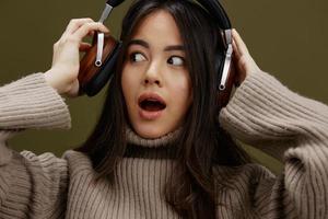 hermosa mujer en auriculares escuchando a música emociones estudio modelo foto