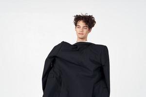 hombre participación un negro chaqueta en su manos Moda moderno estilo auto confianza estudio foto