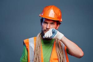 Man in orange paint glove professional construction blue background photo