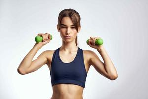 sportive woman with dumbbells in hands pumped up press fitness exercise gym photo