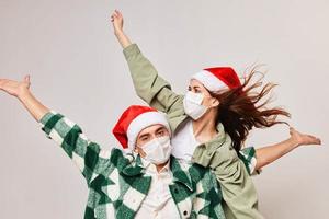 Christmas mood man and woman fun holiday hat medical mask photo