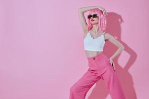 positivo joven mujer en un blanco camiseta y rosado pantalones glamour estudio modelo inalterado foto
