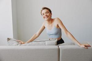 Happy woman smile lying at home on the couch relaxing on a weekend at home with a short haircut hair without filters on a white background, free copy space photo