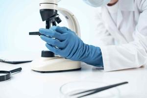 female doctor looking through a microscope biotechnology research laboratory photo