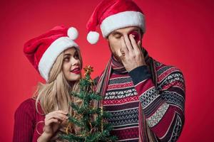 cute young couple celebrate christmas together red background photo