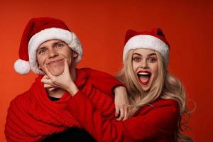 Man and woman in santa hats fun new year holiday isolated background photo