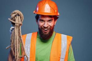 Emotional man in work uniform orange helmet rope professional photo