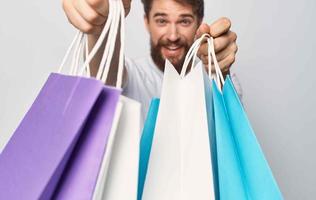 fashion shopping man with multicolored bags in his hands photo