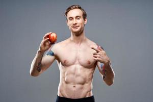 hombre con manzana y deporte sano comida bombeado arriba pastel carrocero foto