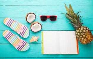 Flip flops, sunglasses and sea shell on blue wooden background. Copy space and fashion summer accessories. photo