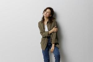 Pensive curly beautiful woman in casual khaki green shirt cross hands think about problems in relationships posing isolated on over white background. People Emotions Lifestyle concept. Copy space photo