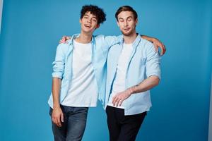 best friends hugging on blue background in matching t-shirts cropped view photo