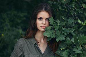 Woman outdoors Shrubs with green leaves look ahead summer photo