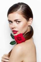 Beautiful woman with rose Looks forward bare shoulders luxury cute face light photo