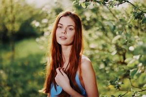 Elegant beautiful young woman portrait smile with teeth in the park in nature in the sunset light of summer photo