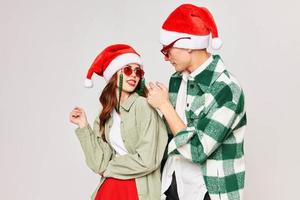 Man and woman in sunglasses Santa hats fashion hugs gray background photo