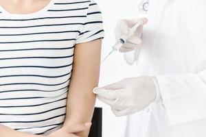 Injection of vaccine into shoulder in hospital close-up photo