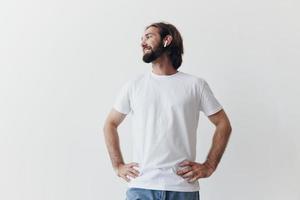 contento hombre escuchando a música y sonriente en un blanco camiseta en un blanco antecedentes contento foto