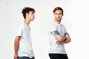 Two cheerful friends in white t-shirts stand side by side cropped view photo