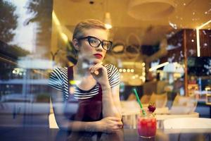 woman alone sitting in a restaurant cocktail vacation dreamy look photo