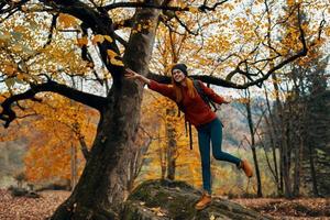happy traveler in park near big tree landscape nature yellow leaves model emotions photo