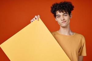 woman man with curly hair holding a poster in his hands studio close-up photo