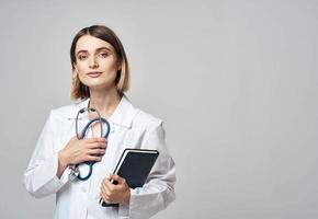 woman doctor with stethoscope and medical gown documents in hands photo