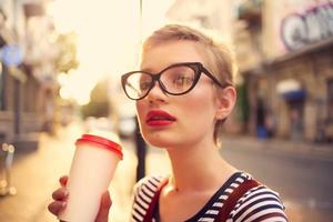 mujer con corto pelo al aire libre vistiendo lentes caminando en verano foto