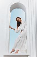 portrait of a woman in a white dress angel window opening posing photo