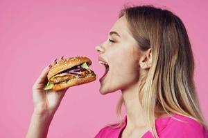 cheerful blonde in a pink shirt hamburger fast food snack photo